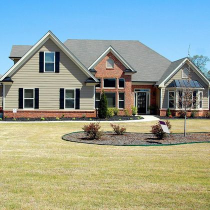 A large house with a lush green lawn in front of it
