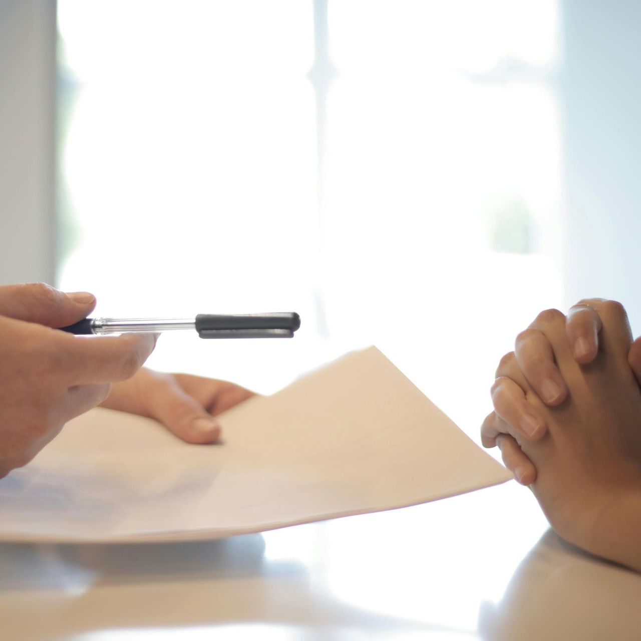 A person is holding a pen over a piece of paper