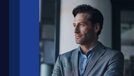 Homem de terno olhando pela janela, simbolizando visão estratégica e gestão de investimentos.