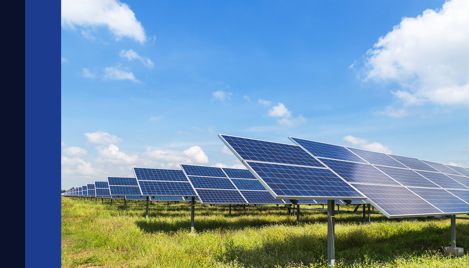 Painéis solares em um campo gramado sob um céu azul.