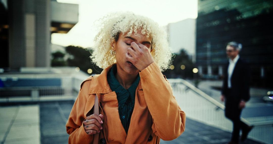 Elderly couple smiles while looking at a laptop on a couch. Woman has arm around man.