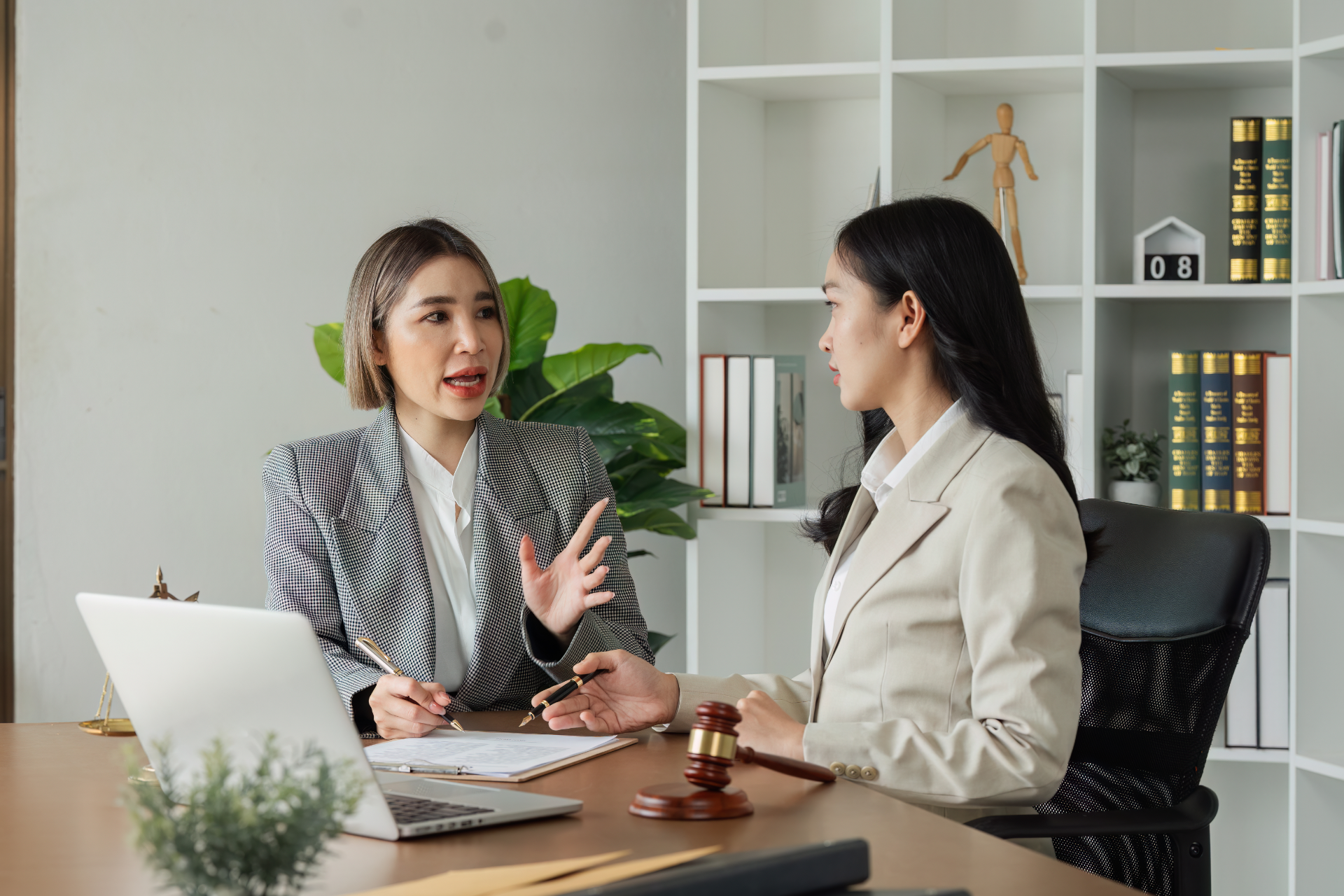 Elderly couple smiles while looking at a laptop on a couch. Woman has arm around man.