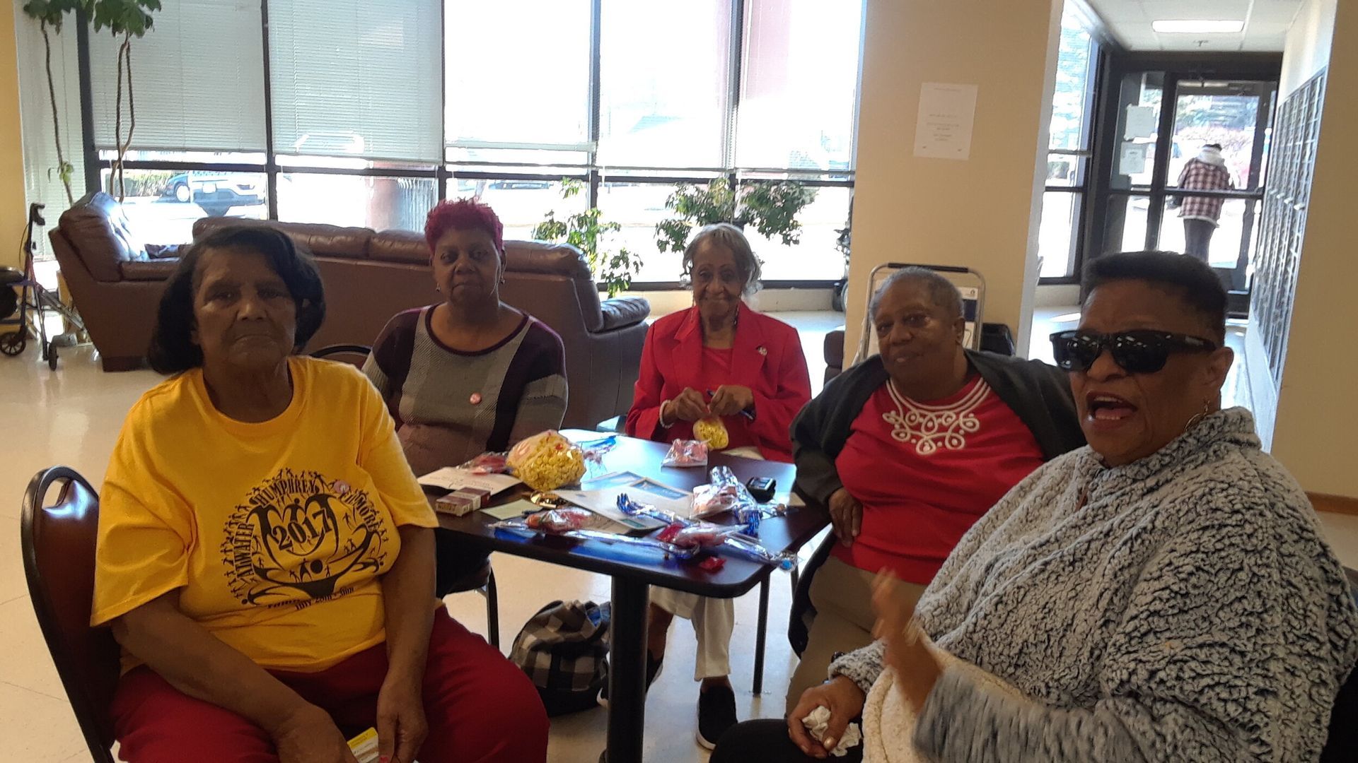 A group of people in an indoor setting with a table.