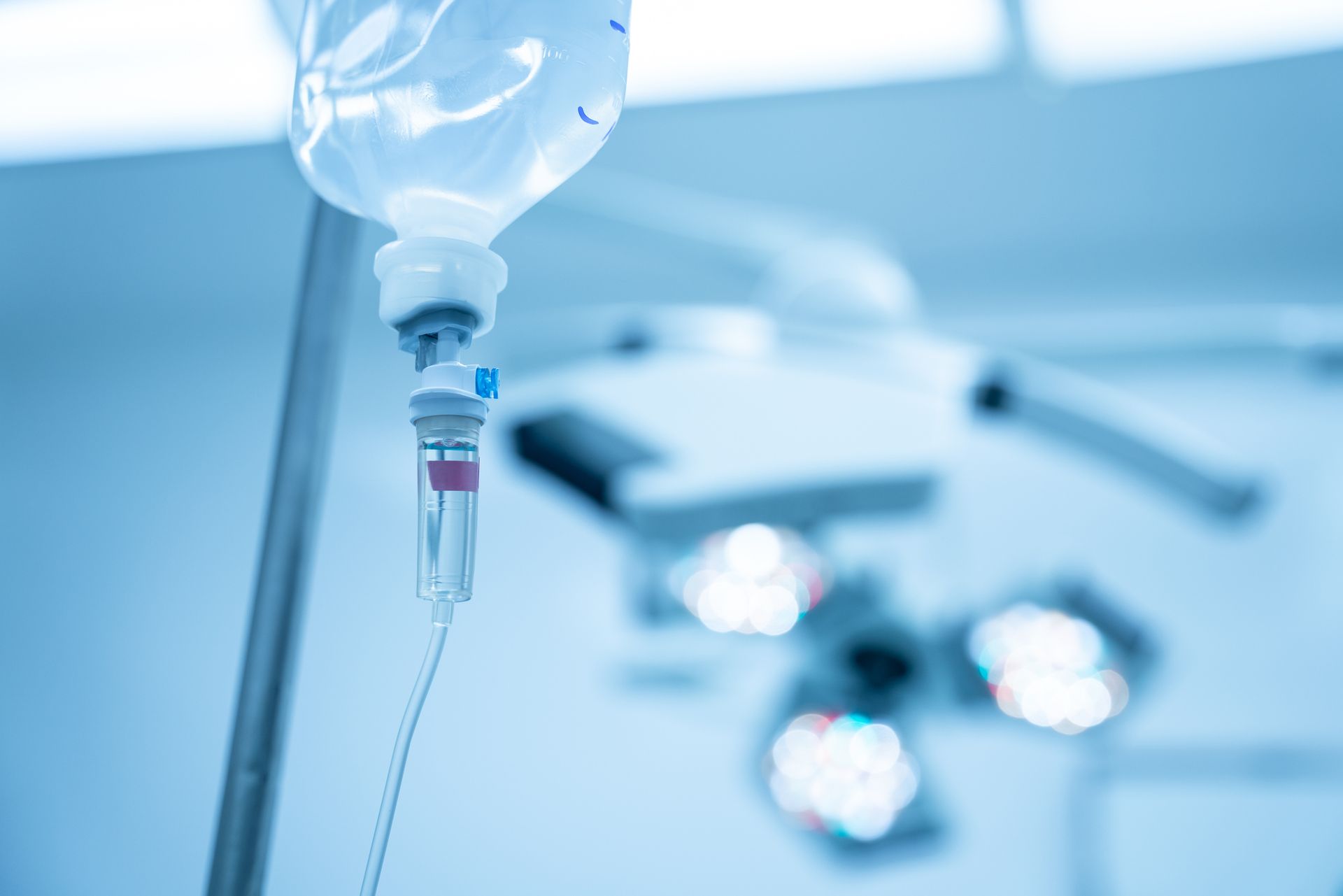 An iv drip is hanging from a pole in an operating room.