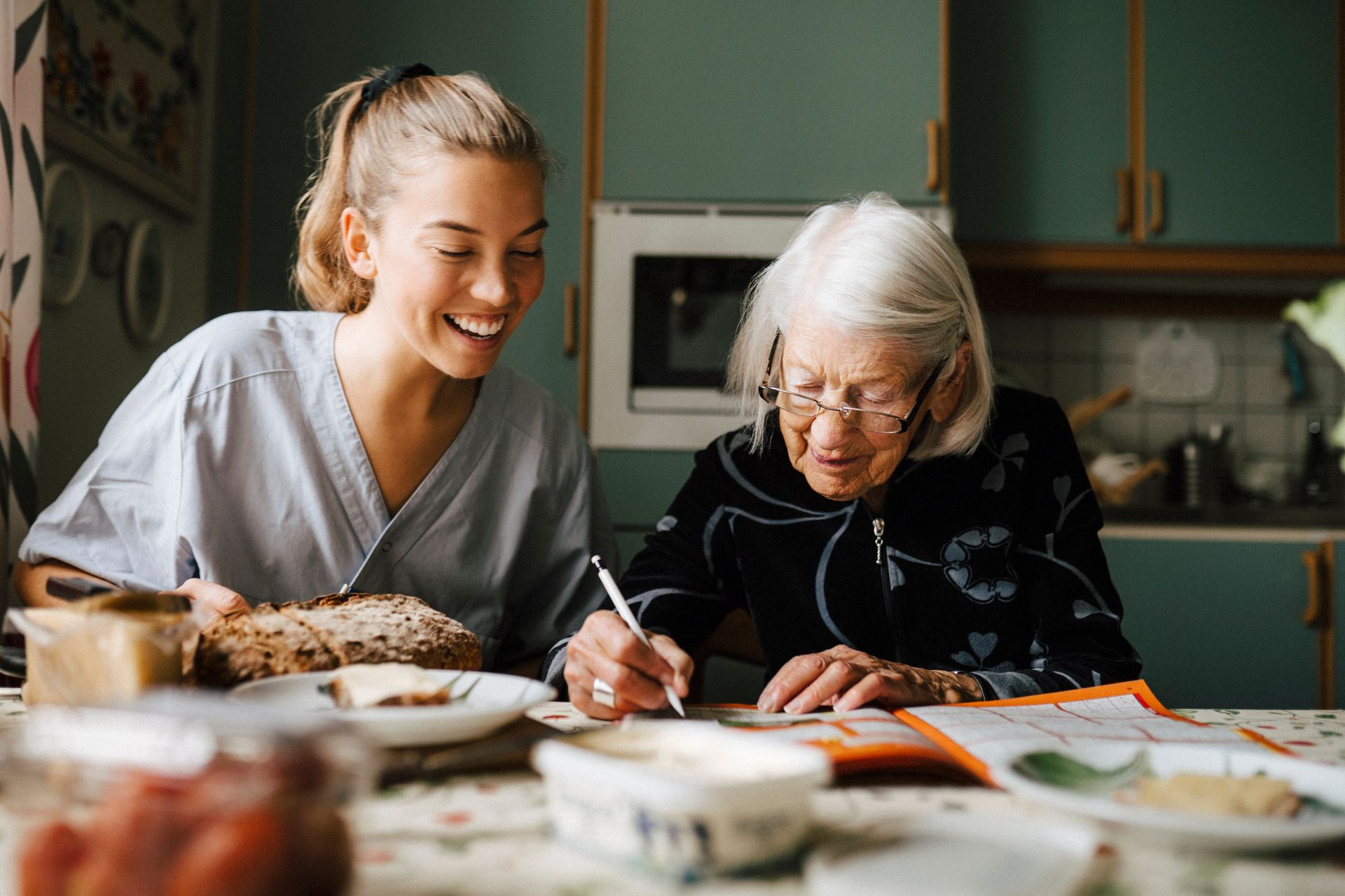 A young woman is sitting at a table with an older woman.