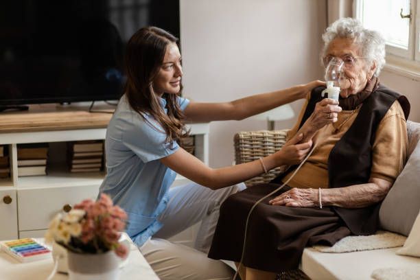 A nurse is helping an elderly woman with an oxygen mask.