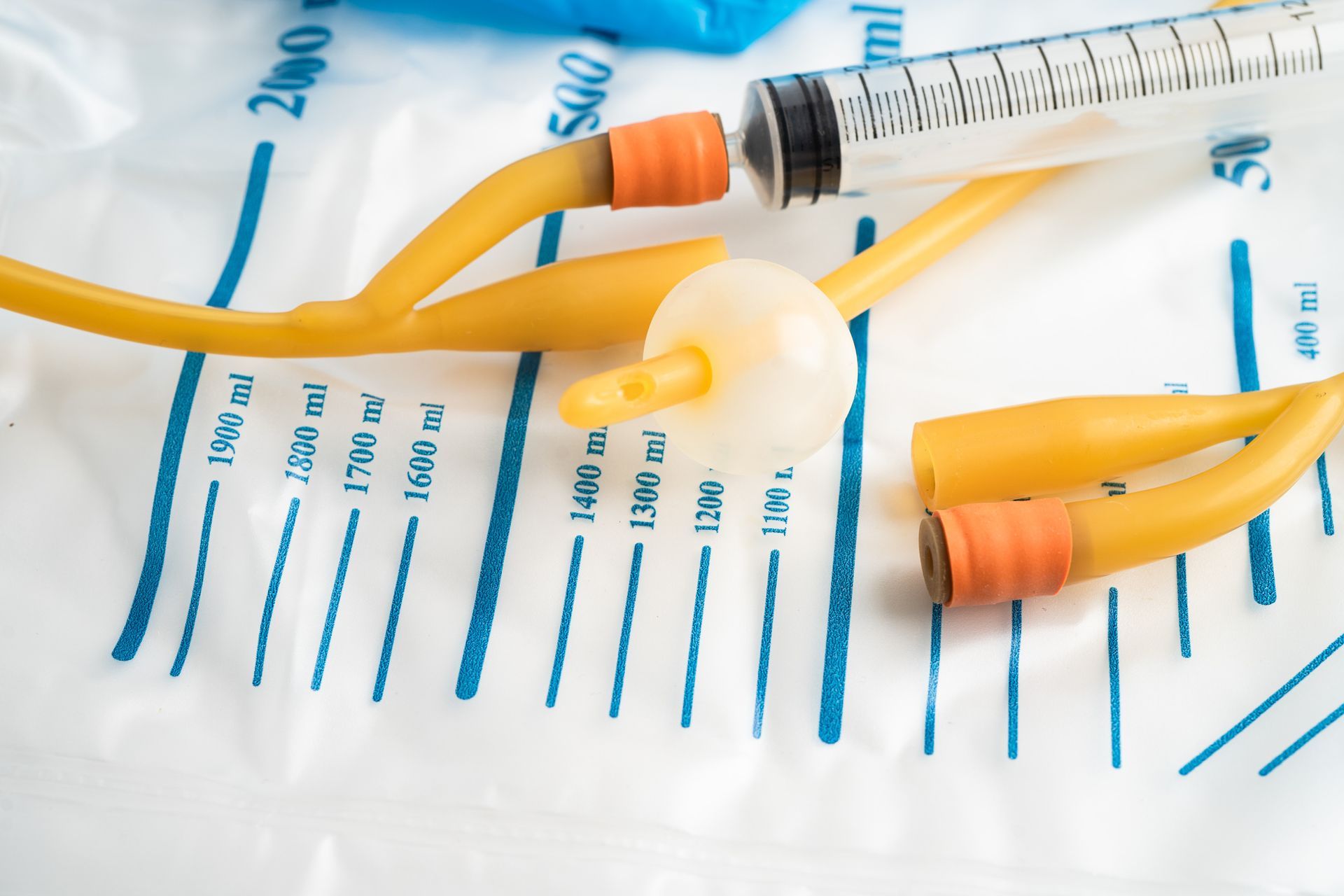 A syringe is sitting on top of a urine bag.
