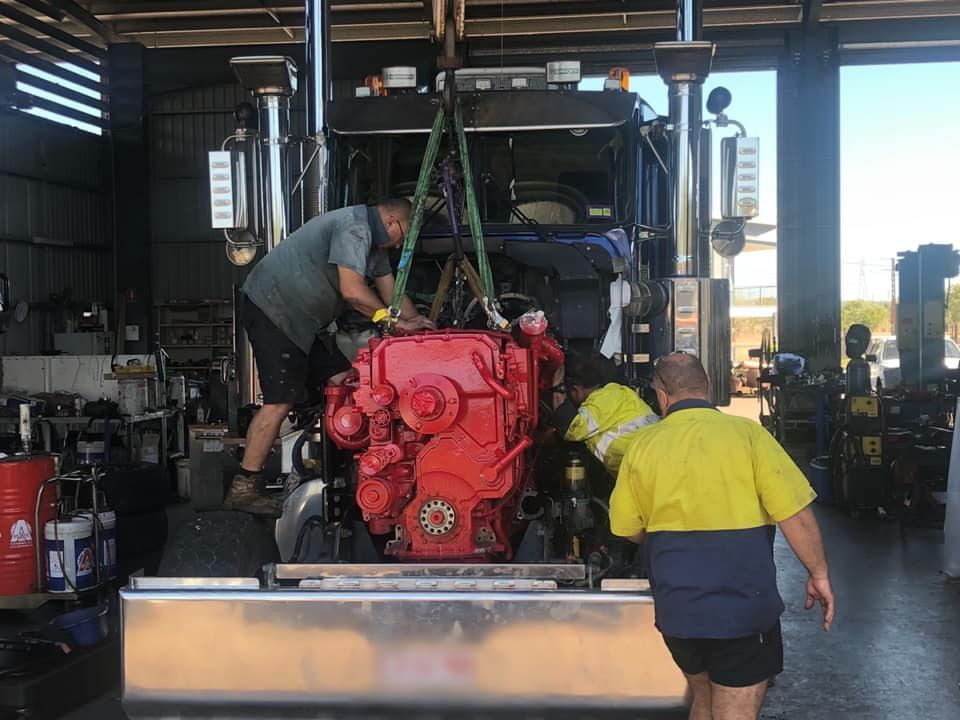 Two Men Are Working on a Red Truck Engine in a Garage — All things Diesel NT in Tivendale, NT 
