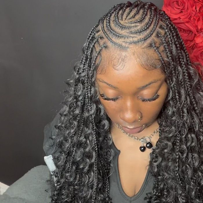 A person with intricate braided hair that transitions into long, loose curls, with stylized edges and a dark background.