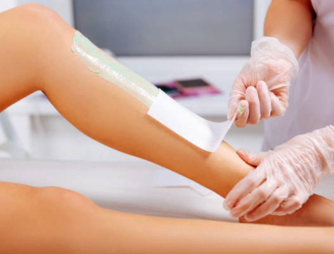 A woman is getting her legs waxed in a beauty salon.