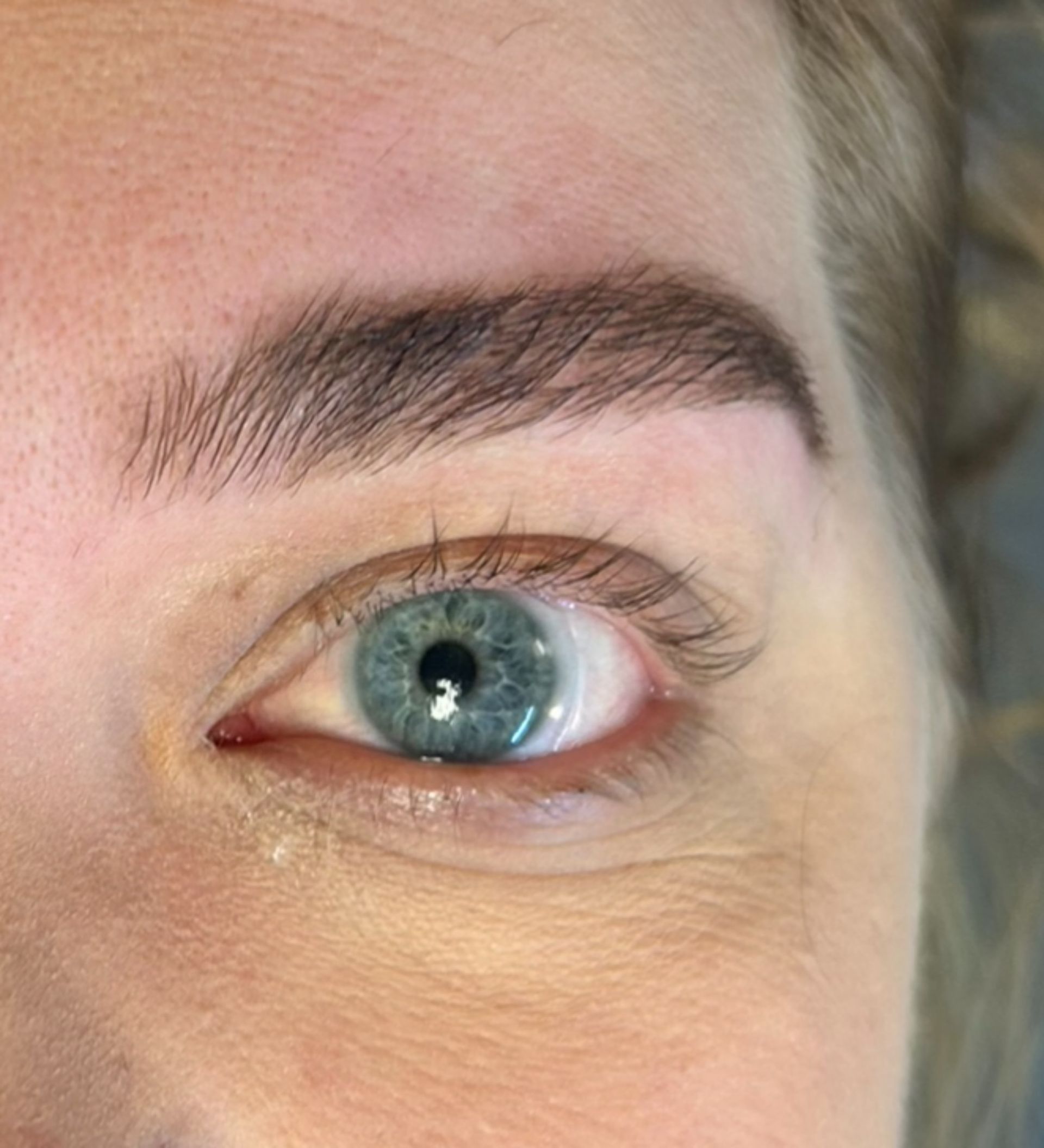 A close up of a woman 's blue eye and eyebrows.
