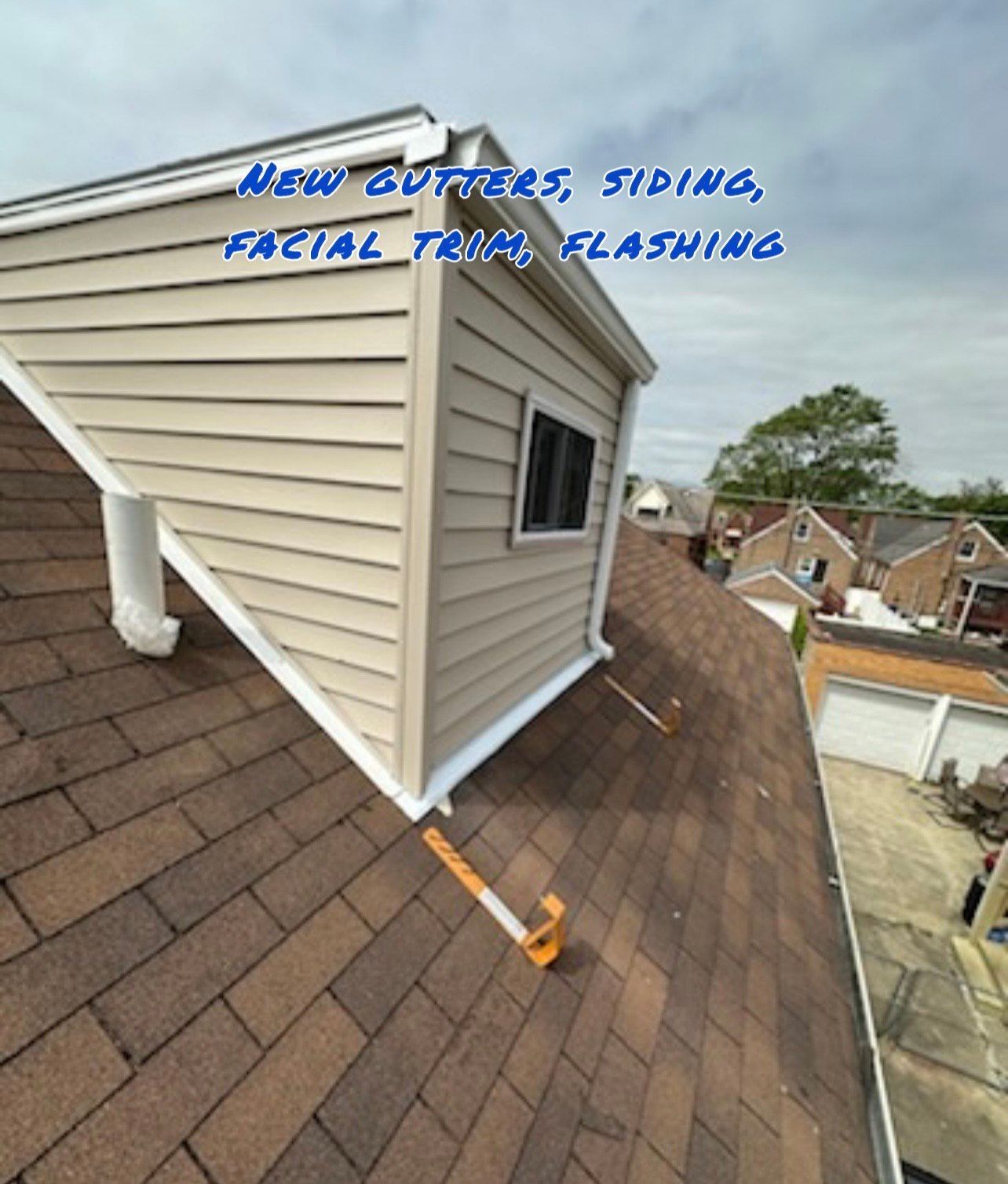 Roof with new gutters, siding, facial trim, and flashing. Beige siding, brown shingles, white trim.