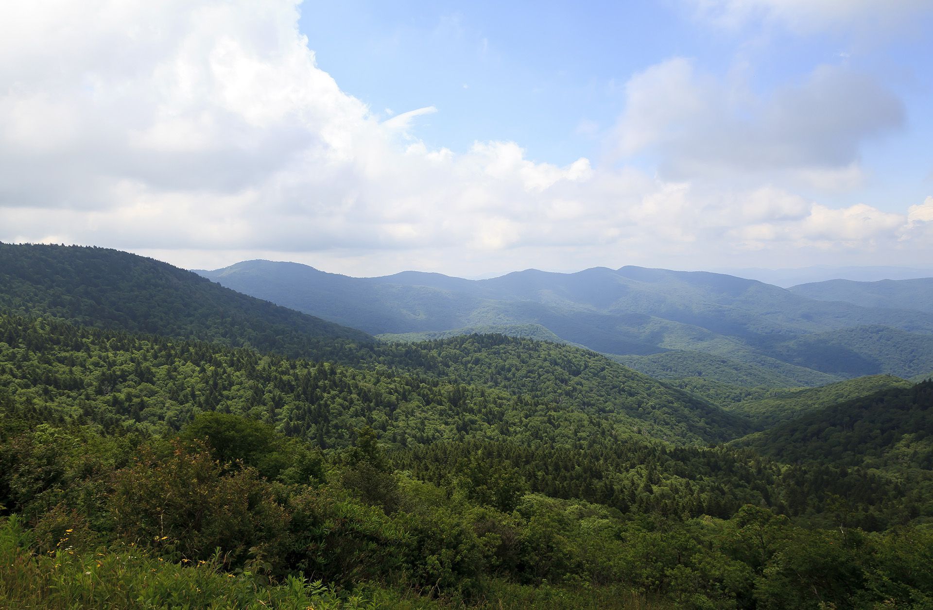 a sunset over a mountain range with a cloudy sky