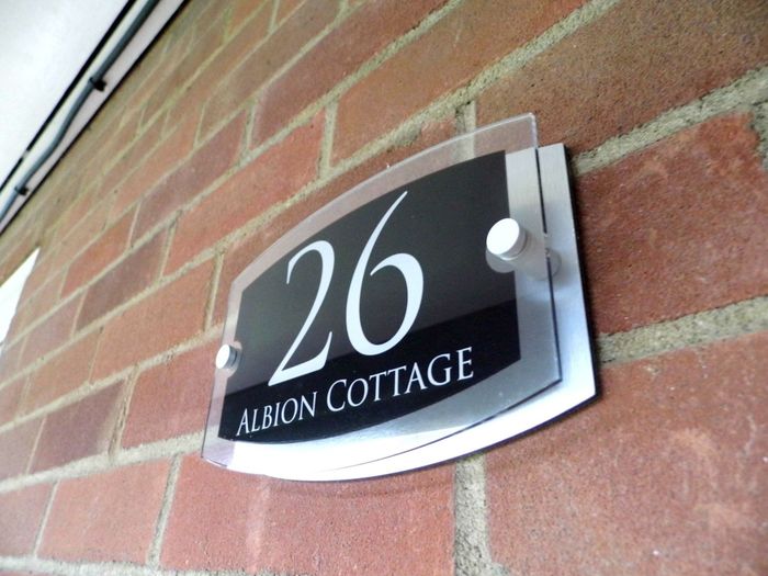 Albion Cottage name plate on wall at front door.