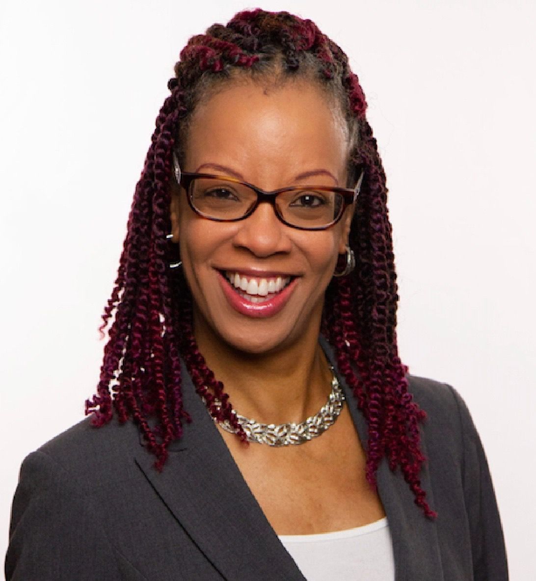 A man and woman shaking hands with a woman smiling in the background