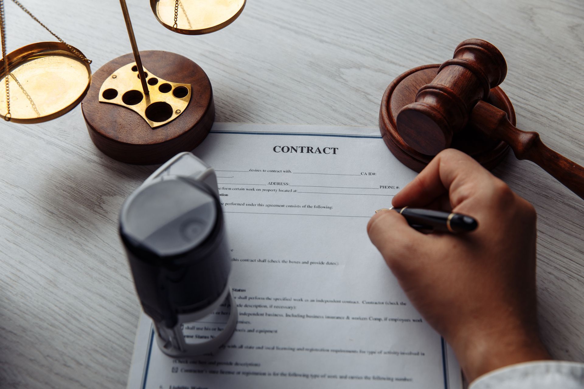 A woman is putting a stamp on a piece of paper.