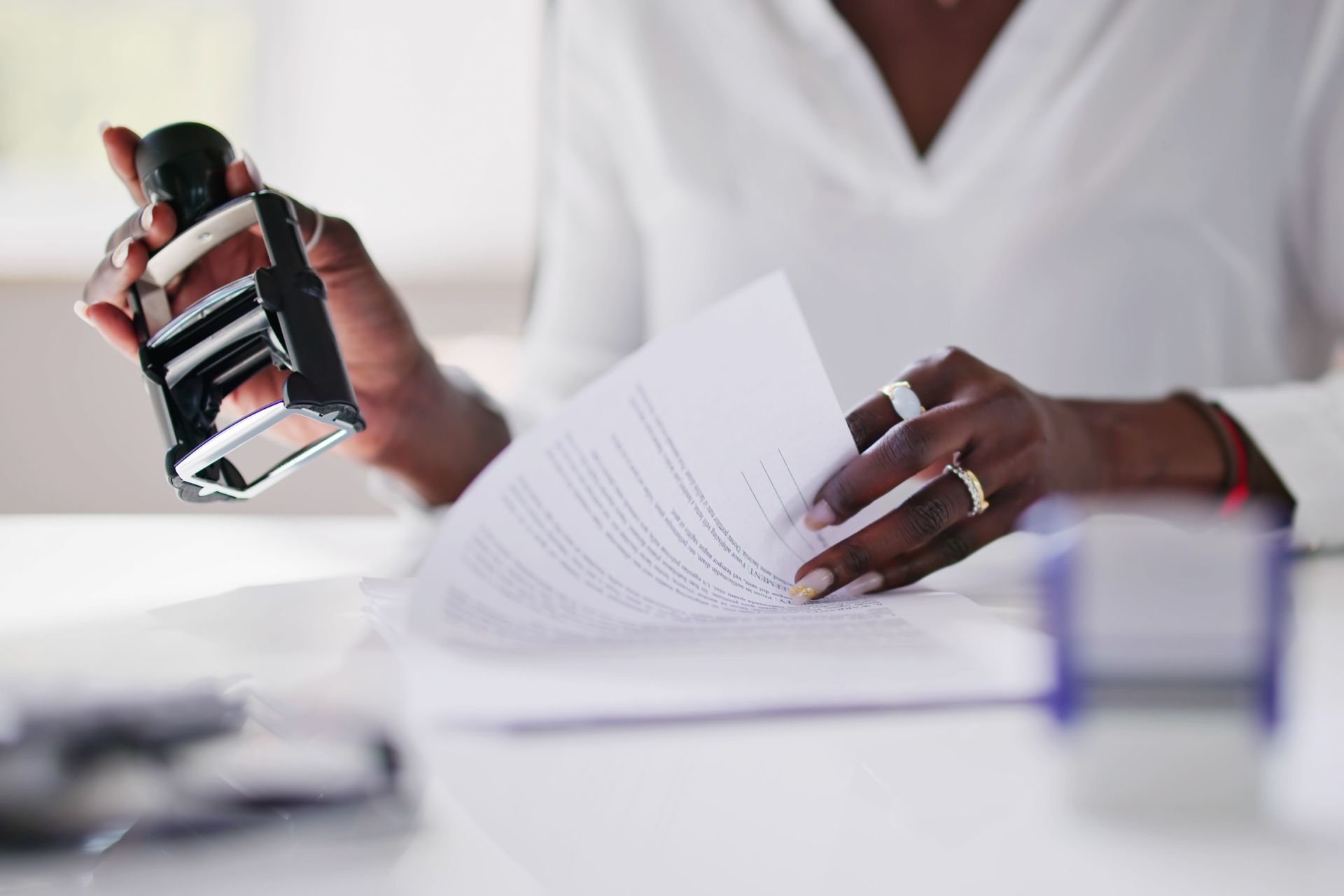 Two women are sitting on a couch looking at a piece of paper.