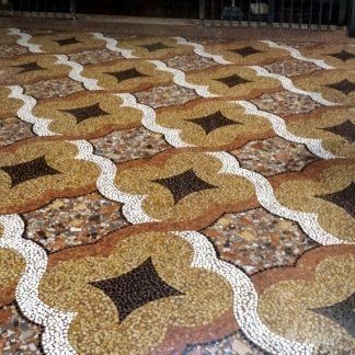 Un pavimento piastrellato caratterizzato da un motivo ripetuto di forme quadrilobate color marrone chiaro, delineate in bianco, con al centro dei diamanti marrone scuro.