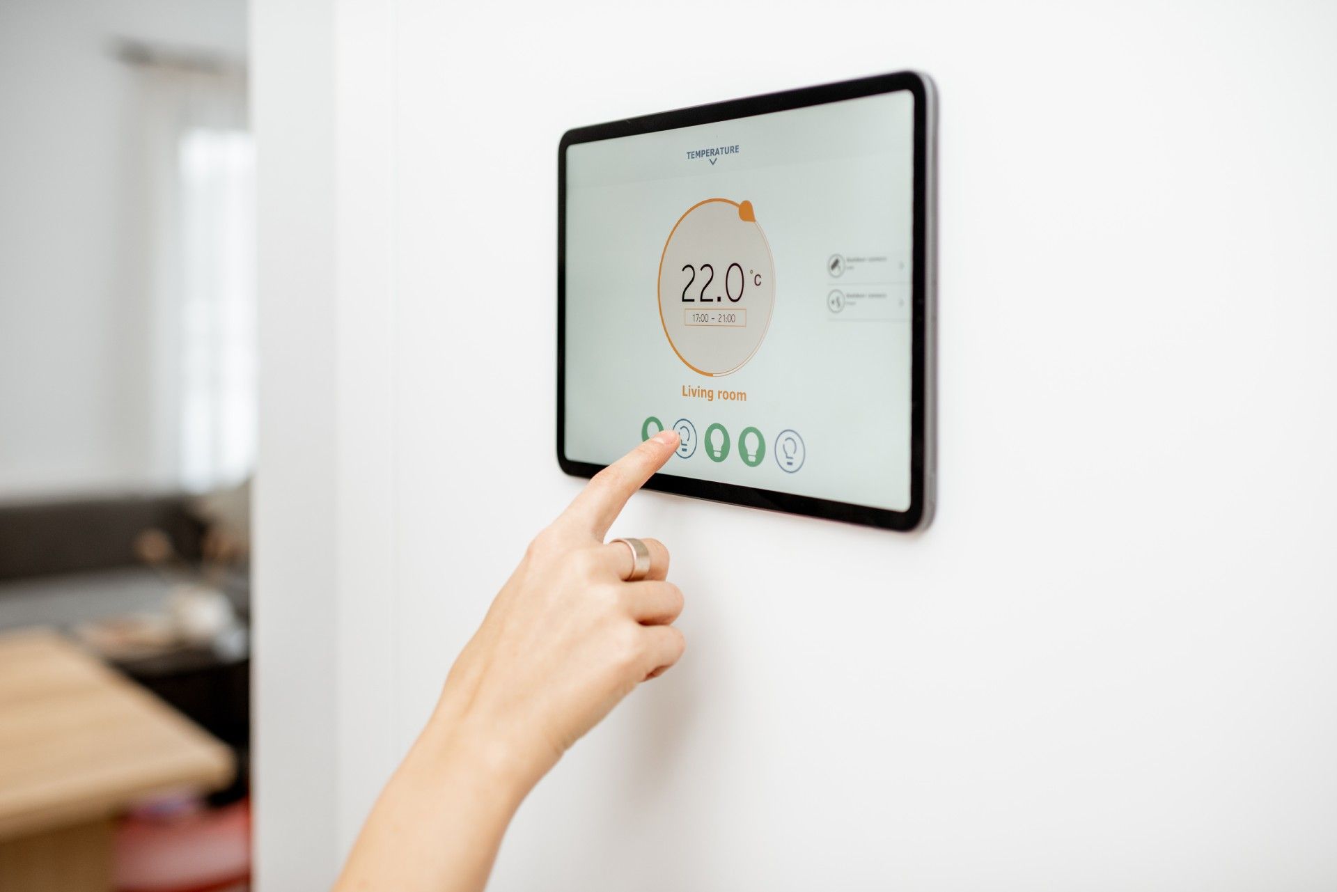 A person is using a tablet to control a thermostat.