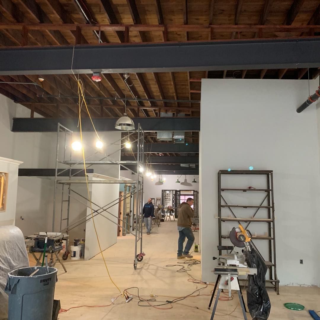 A man is standing in a room that is being remodeled