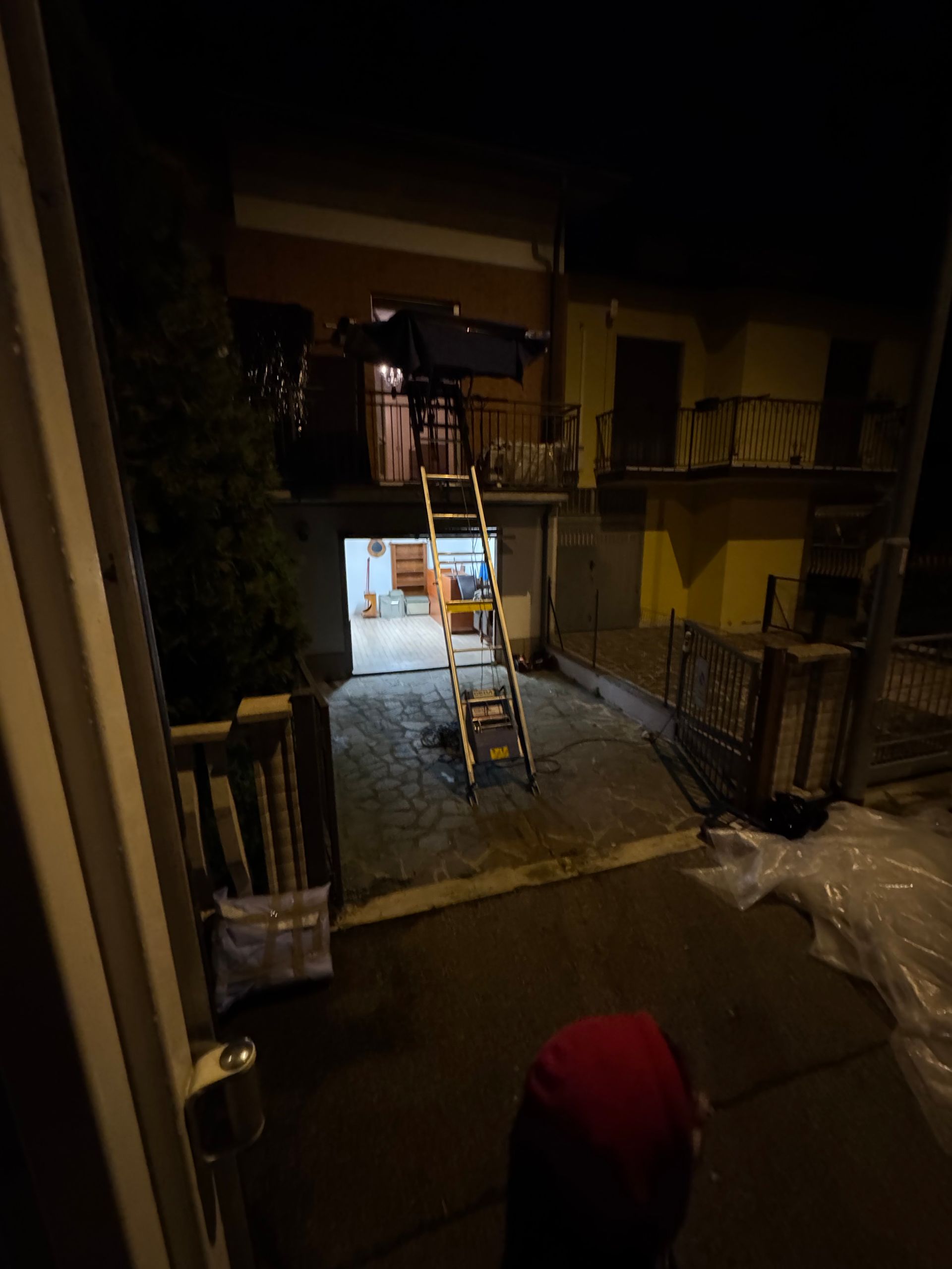 Una persona è in piedi davanti alla porta di un garage di notte.
