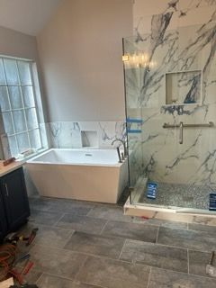 A bathroom with a bathtub and a walk in shower.