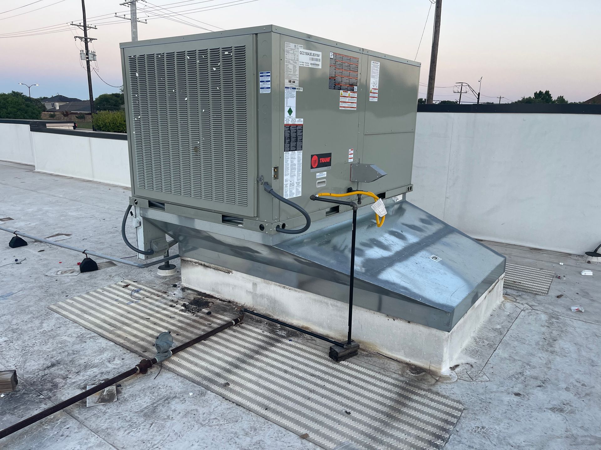 A large air conditioner is sitting on top of a roof.