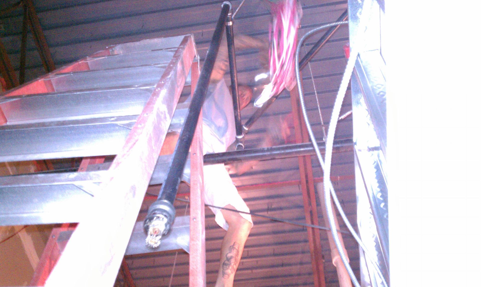 A person is standing on a ladder in a dark room