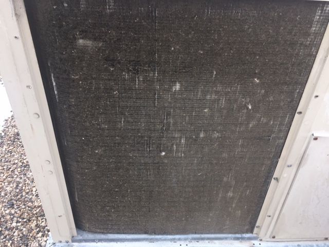 A close up of a dirty radiator on a building