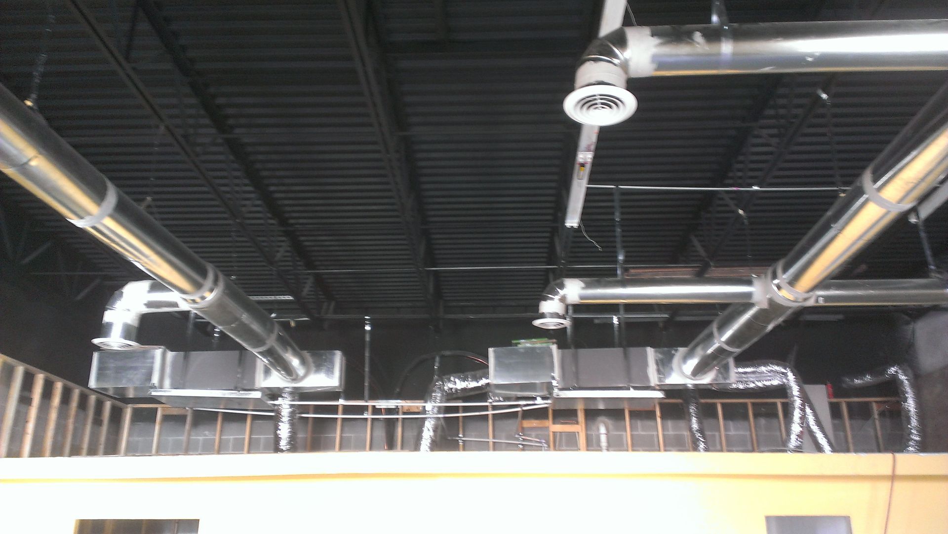 A ceiling with a lot of pipes hanging from it