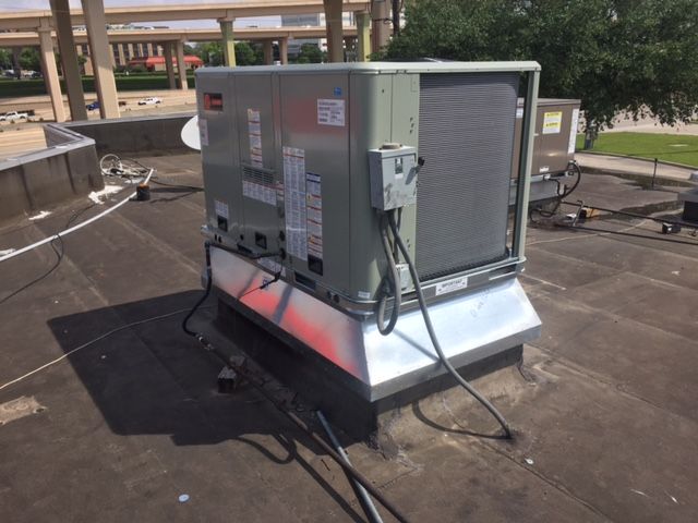 An air conditioner is sitting on top of a roof