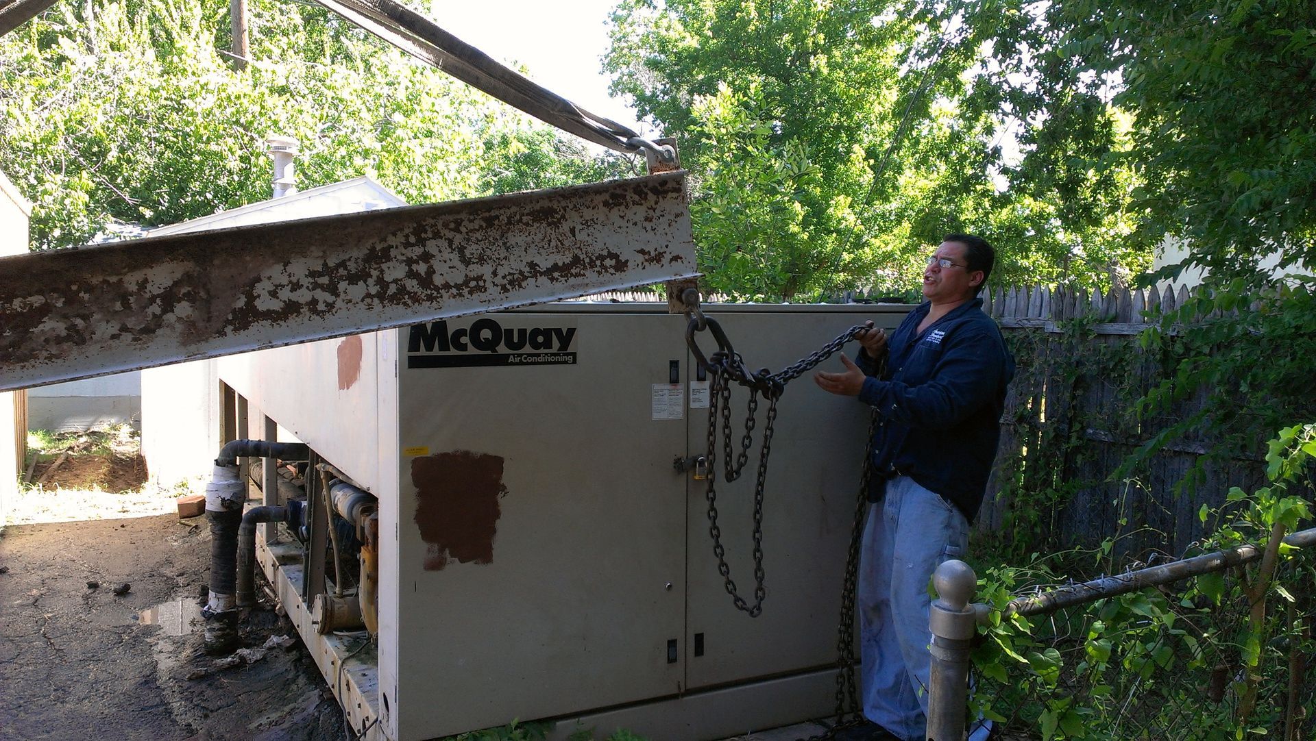 A man is standing next to a mcquay machine