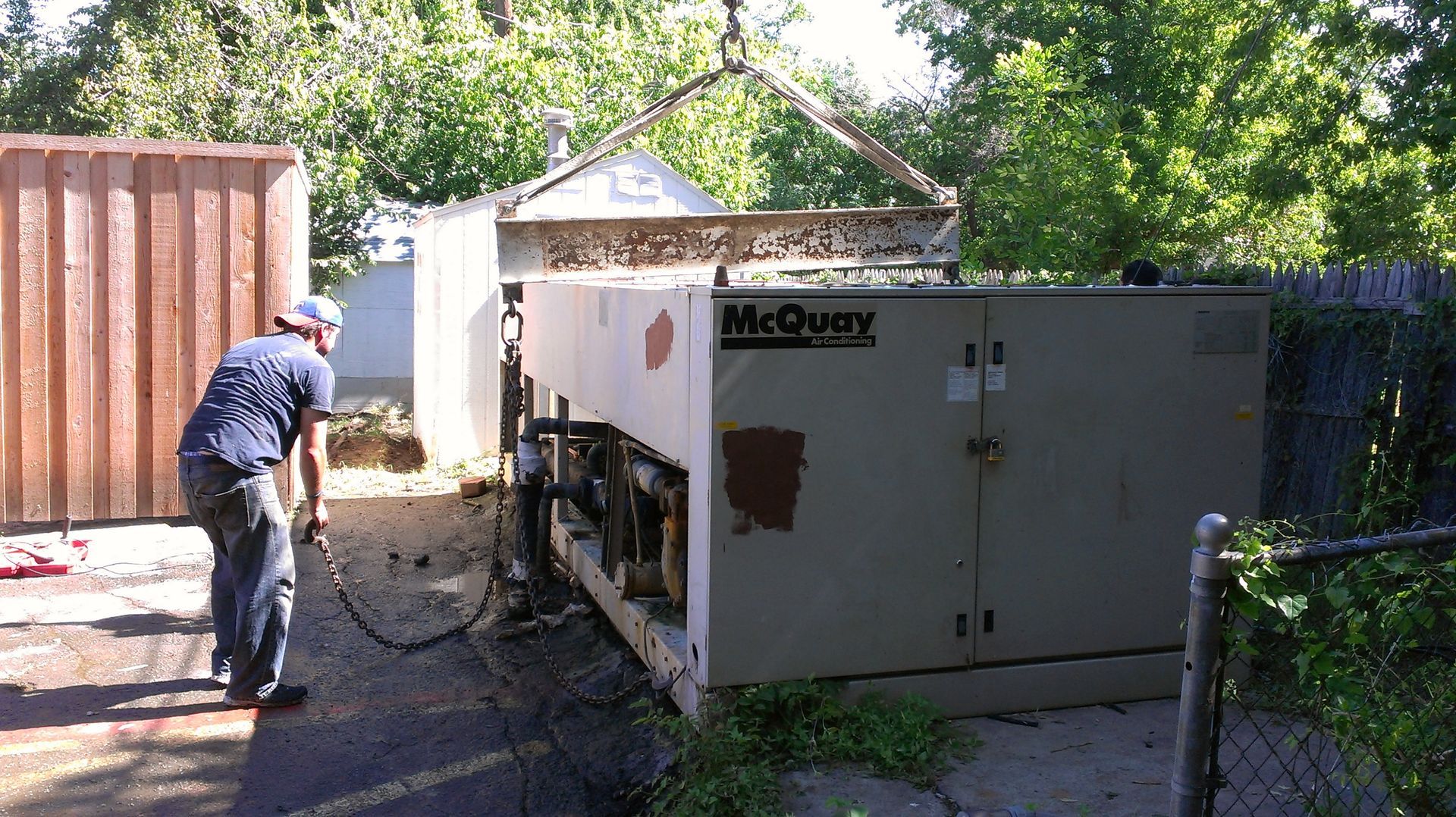A man is standing next to a mcquay machine