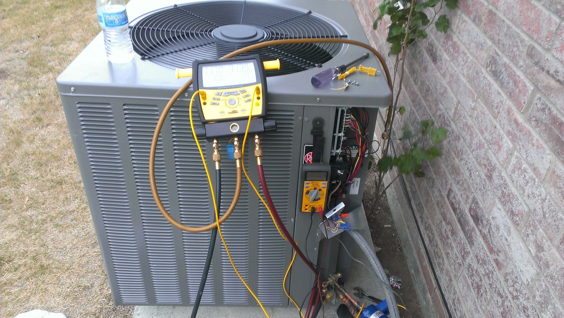 An air conditioner is being serviced by a technician.