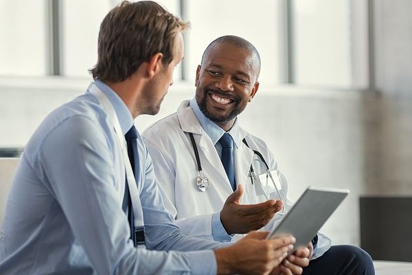 Orphan drug consultant and physician sitting together 