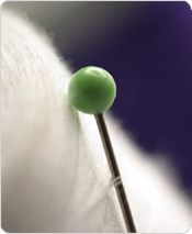 A close up of a pin with a green ball on it.
