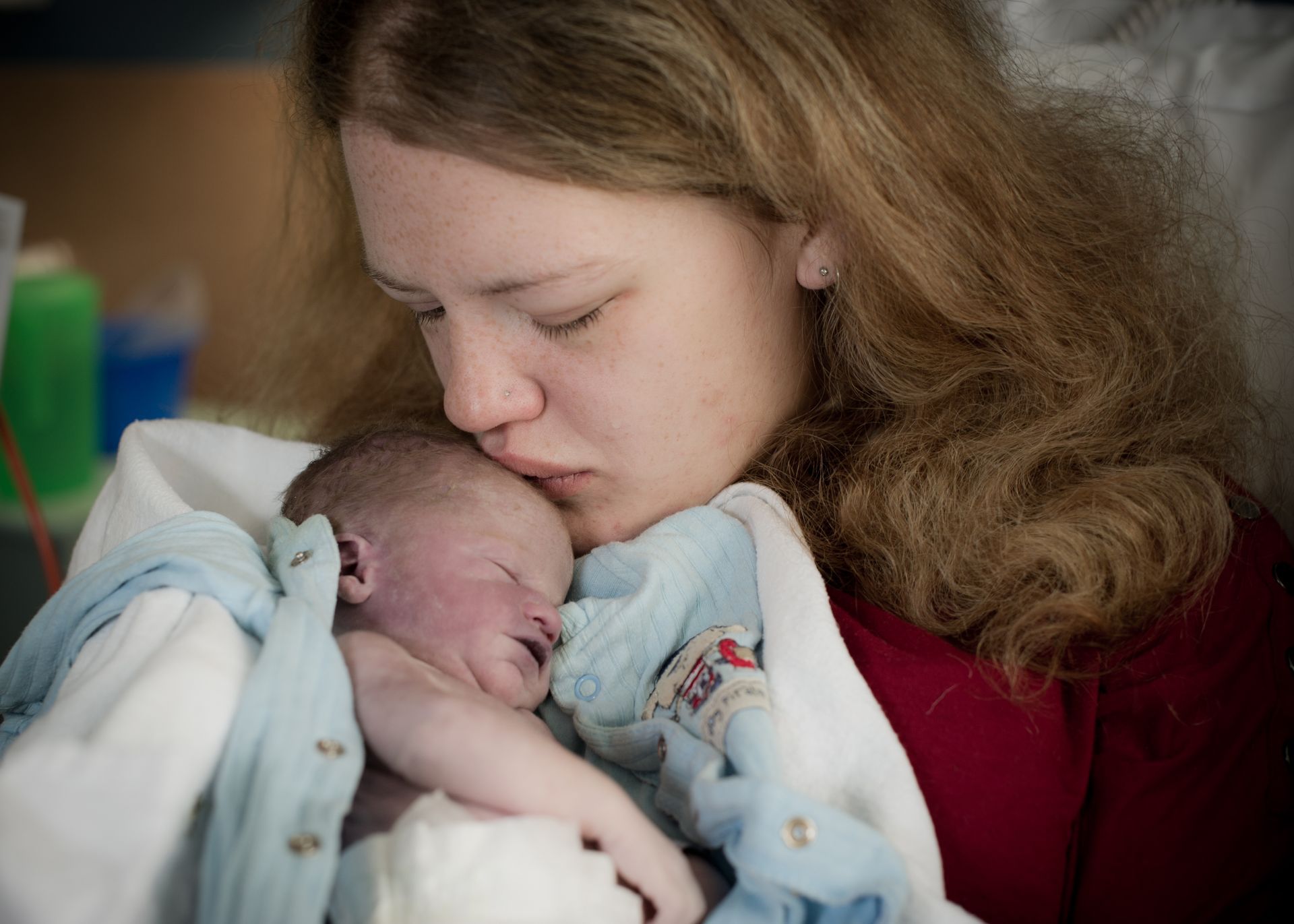 A woman is holding a newborn baby in her arms.