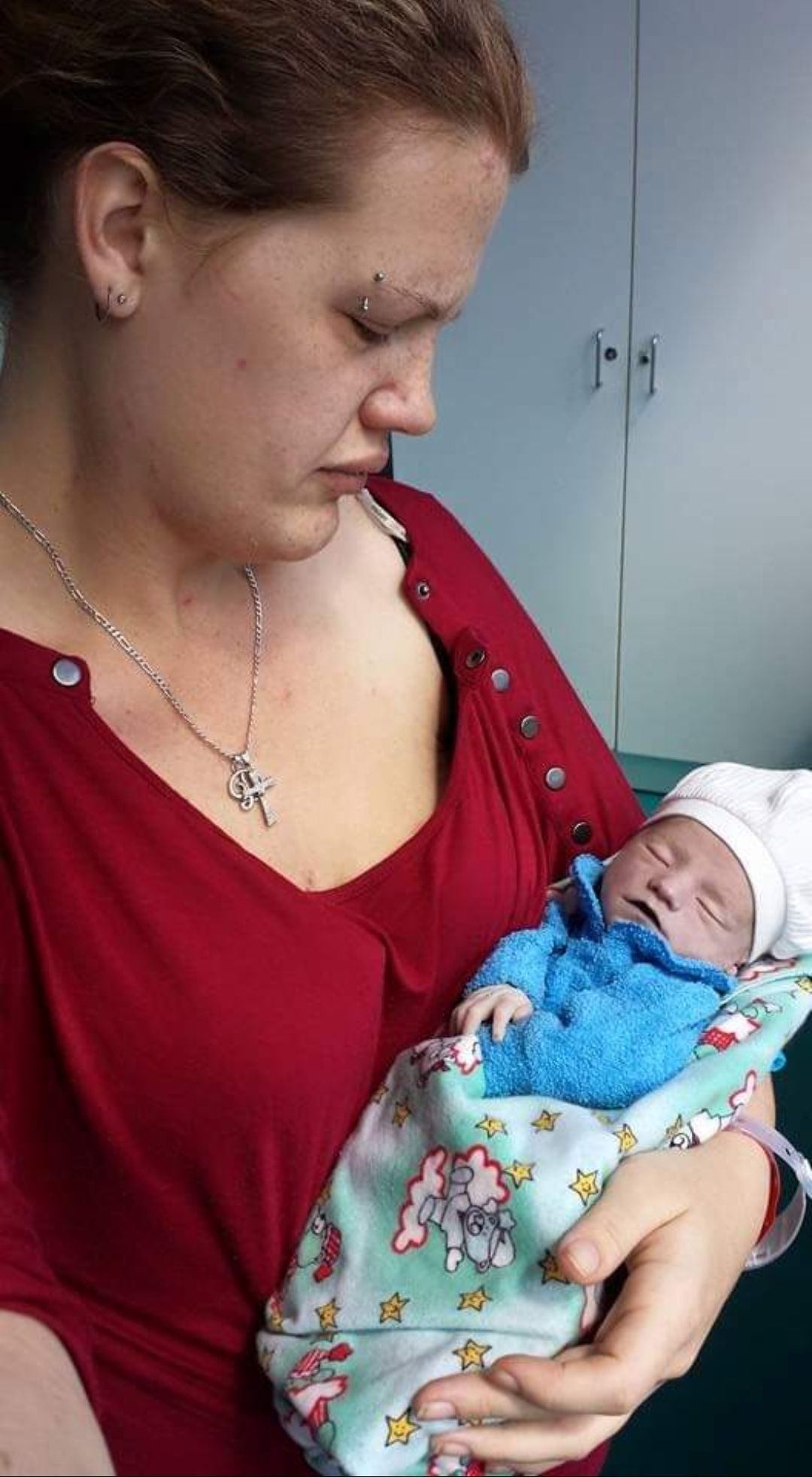 A woman is holding a newborn baby in her arms.