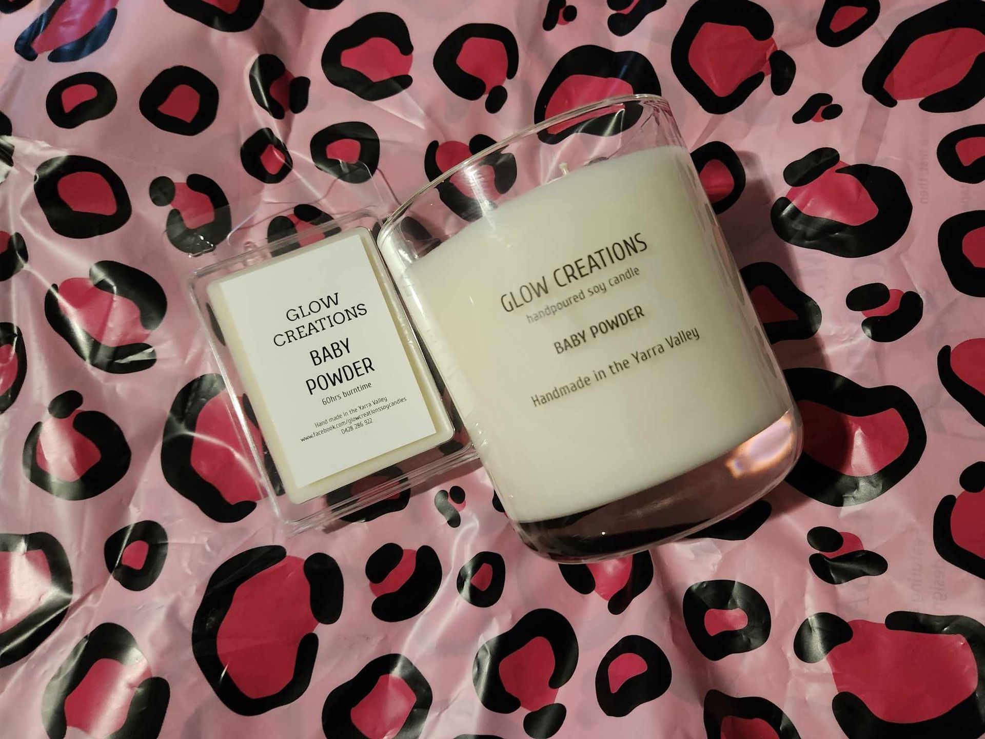 A candle is sitting on top of a pink leopard print blanket.