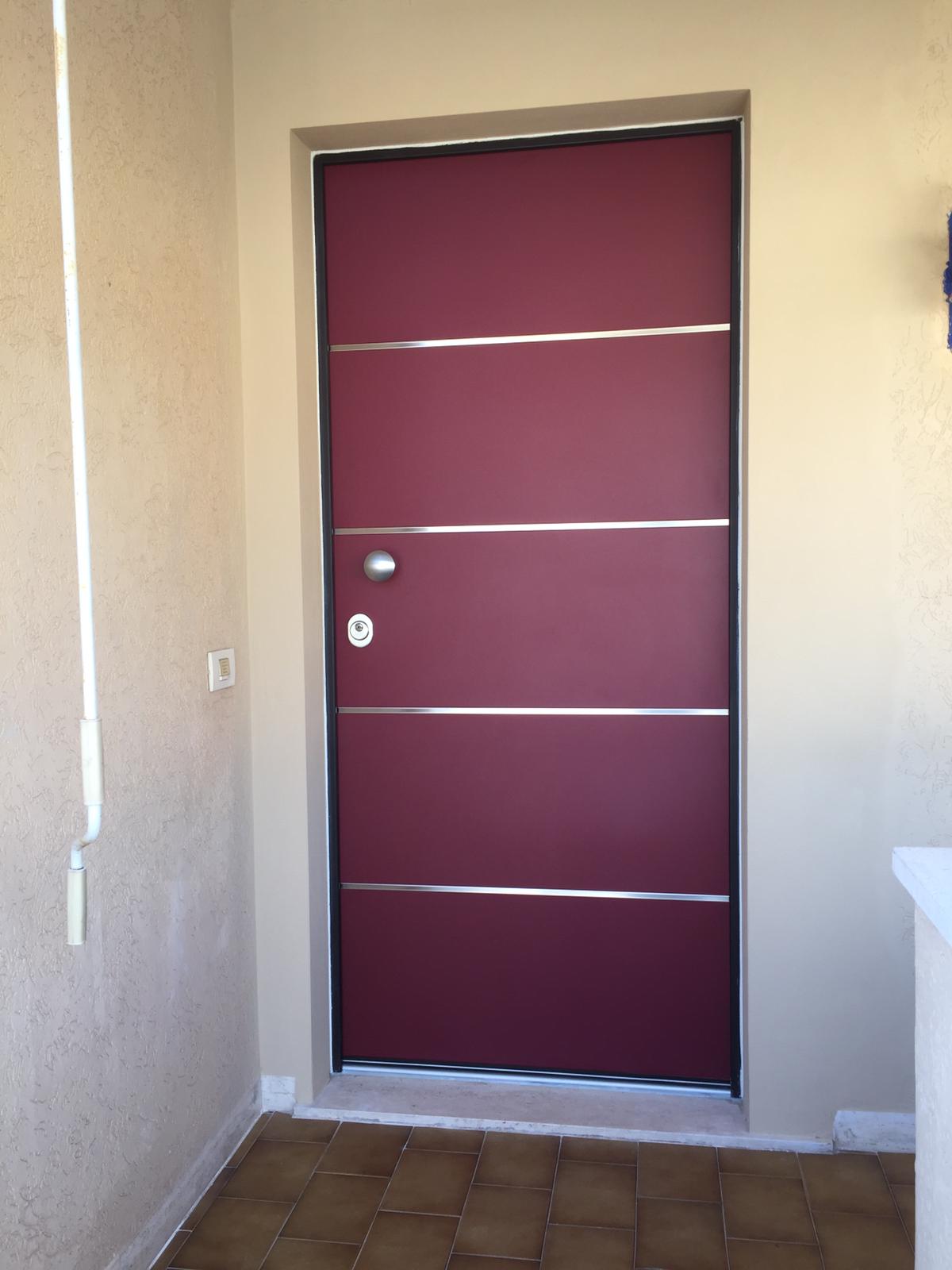 Porta color marrone con strisce orizzontali argentate e maniglia, inserita in un vano porta beige.