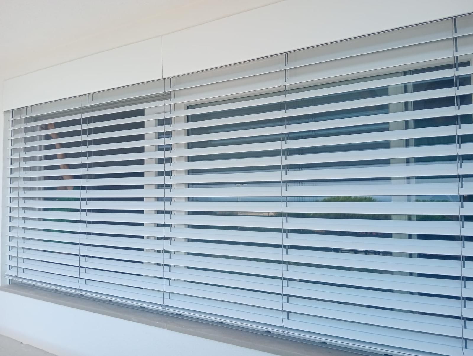 Porta da garage marrone con una porta più piccola incorporata. Vialetto in mattoni davanti.