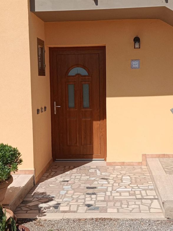 Parete in stucco arancione con finestra e persiana; unità di aria condizionata sopra.