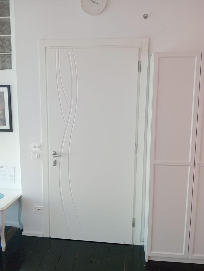 Due ante di un armadio in legno chiaro in una stanza bianca.