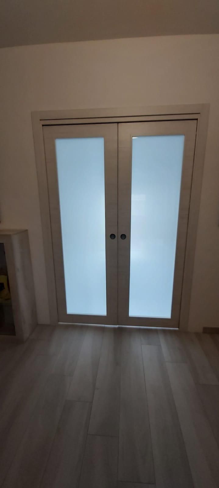 Facciata rossa dell'edificio con due finestre bianche con persiane e aria condizionata.