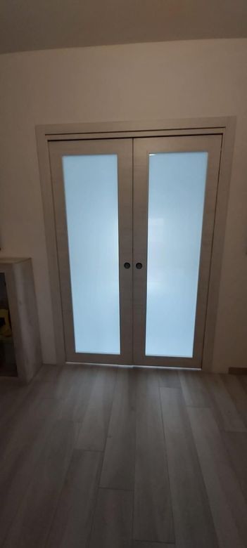 Facciata rossa dell'edificio con due finestre bianche con persiane e aria condizionata.