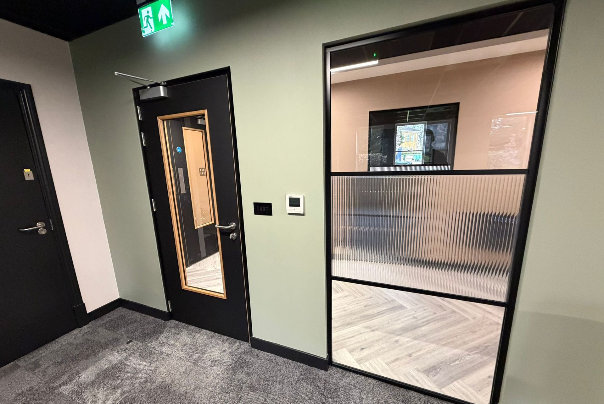 Crittall style aluminium glass partition with black glazing bars 