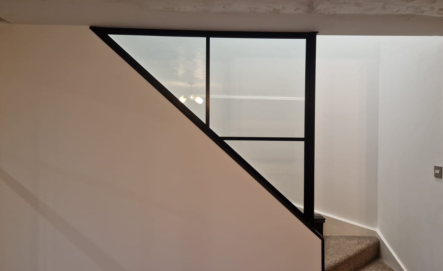Bespoke triangular glass barrier screen over staircase in Northumberland home by Clear Divide