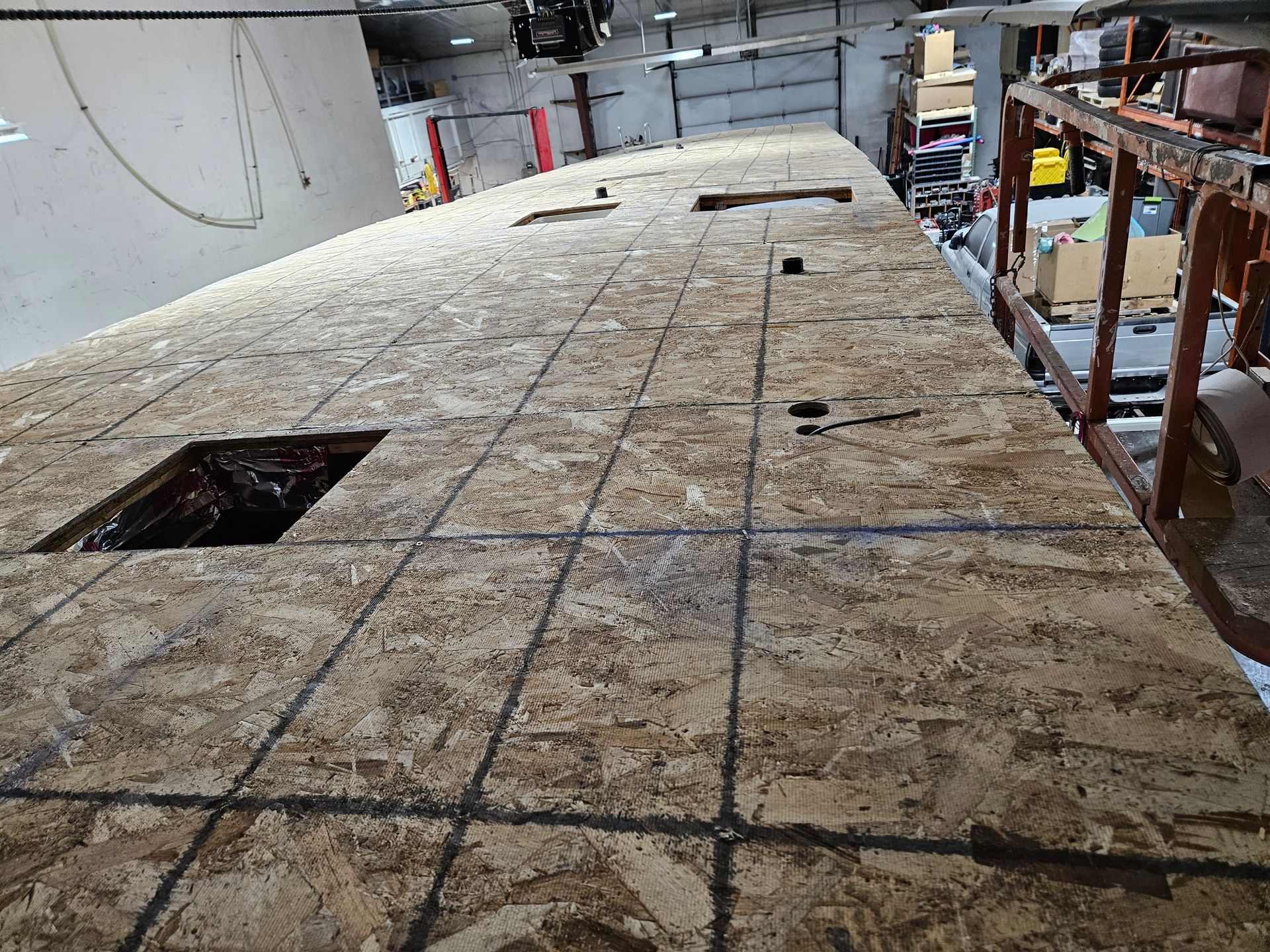 Construction site with a curved wooden floor deck and rectangular cutouts under renovation