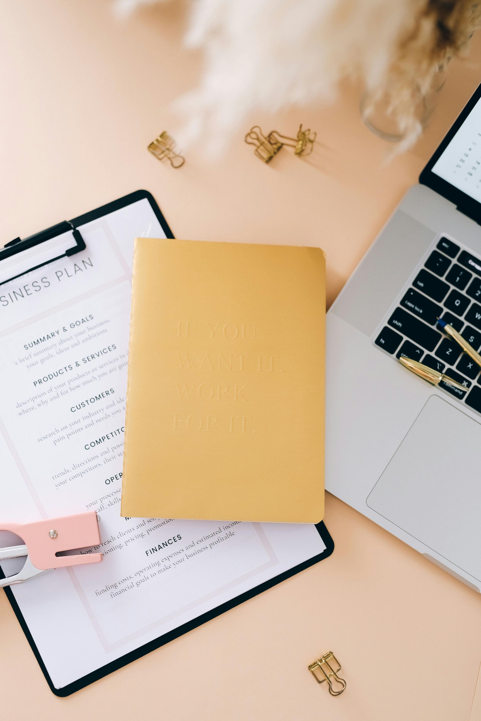 Business plan document and laptop on a desk.