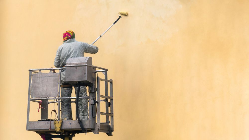 Man Painting Wall with Roller — NBM Constructions in Wodonga